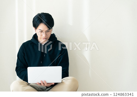 Man using a computer by the wall 124863341