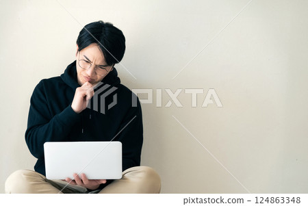 Man using a computer by the wall 124863348