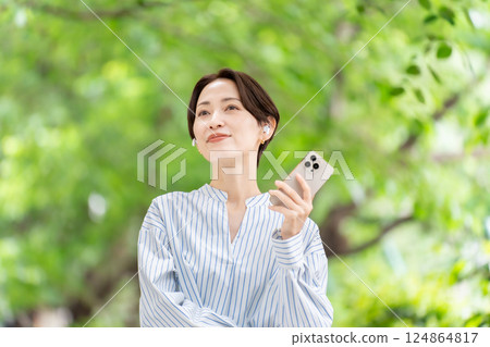 用耳機聽音樂的女人，鮮綠色 124864817