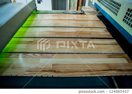 Production line of the wooden floor factory. CNC automatic woodworking machine. Production line of the wooden floor factory. CNC automatic woodworking machine. 124865437