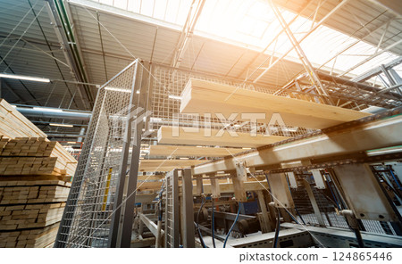 Production line of the wooden floor factory. CNC automatic woodworking machine. Production line of the wooden floor factory. CNC automatic woodworking machine. 124865446