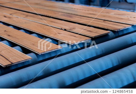 Production line of the wooden floor factory. CNC automatic woodworking machine. 124865458