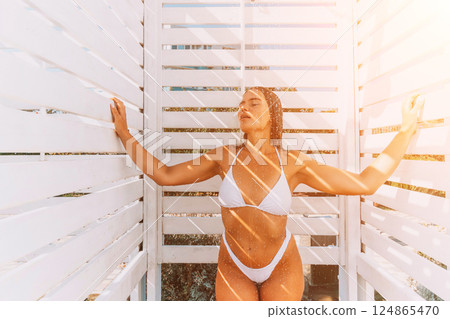 Woman Beach Shower Summer: White changing room, sunlit tan, relaxation. 124865470