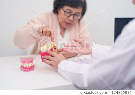 Elderly Patient consulting Dentist to Tooth disease, Senior Health Medical Diagnosis. Anatomy teeth model for Oral Teeth decay, Scrape off tartar. March Oral health, Dentist Day, False Teeth concept 124865985