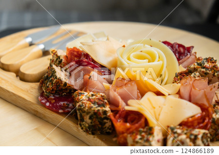 Wooden charcuterie cheese board holiday present idea. Snack starter plate for dinner with wine. Italian appetizers or antipasto set with gourmet food. Buffet party 124866189