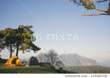 landscape and travel concept with asian man relax see sunset camping tent on mountain 124866306