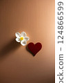 A red heart and white flower on a rich brown background 124866599