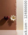 A red heart and a white flower are elegantly placed on a table 124866600