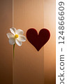 A white flower with a red heart on a textured brown background 124866609