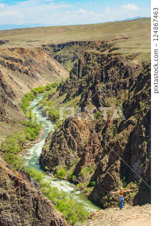 girl against the backdrop of rocky mountains in the Almaty region. rocky plain in Kazakhstan 124867463