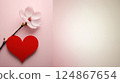 A red heart and a white flower on a soft pink background 124867654