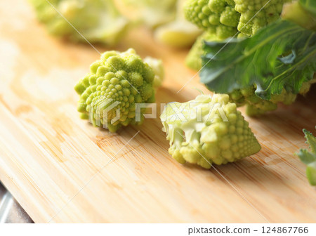 Sliced florets of Romanesco broccoli cabbage on wooden board in kitchen. Healthy eating. Food and green vegetables. 124867766