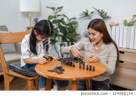 Family Games and Togetherness. A touching moment during a domino game highlights familial love and interaction. 124868134