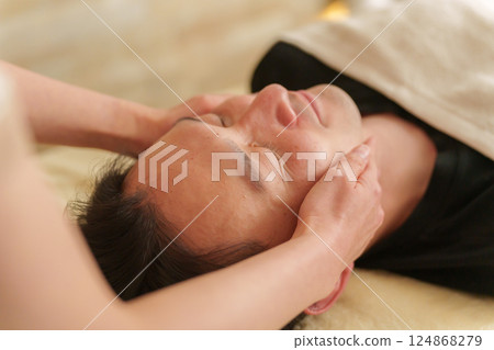 一位男顧客在美容院接受臉部按摩 124868279