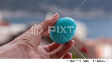 Turquoise Easter eggs coloring activity with bright turquoise egg decorated in a scenic outdoor setting during Easter celebration 124868758