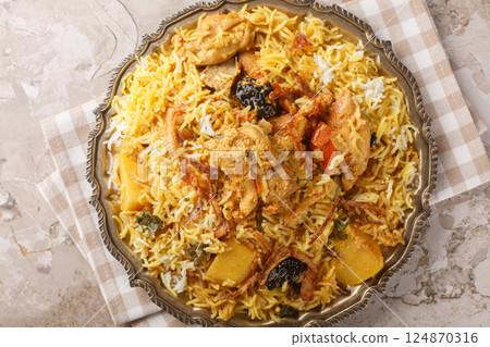 Sindhi Biryani made using chicken, basmati rice, yogurt, onions, green chillies, potatoes and tomatoes closeup on the plate. Horizontal top view 124870316