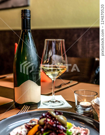 delicious romantic Gala dinner table setting with bottle glass of wine, laid table, side view food porn 124870520