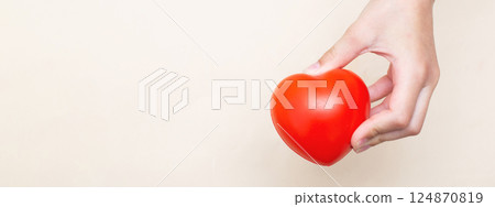 Children's hands holding a red heart as a simbol of care, love, and protection 124870819