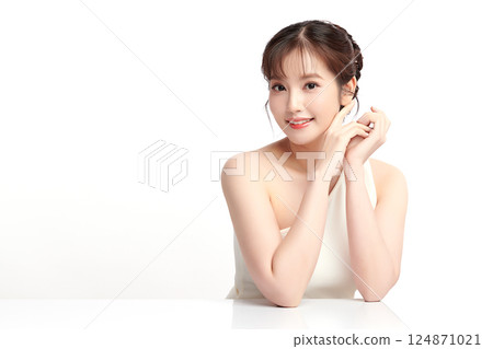 A beautiful young Asian woman with clean, fresh skin against a white background. Skincare, facial treatment, cosmetology, beauty, and spa. An elegant portrait of an Asian woman. 124871021