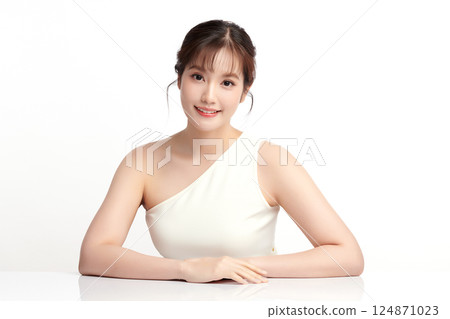 A beautiful young Asian woman with clean, fresh skin against a white background. Skincare, facial treatment, cosmetology, beauty, and spa. An elegant portrait of an Asian woman. 124871023