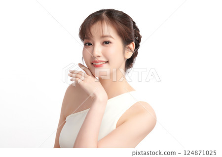 A beautiful young Asian woman with clean, fresh skin against a white background. Skincare, facial treatment, cosmetology, beauty, and spa. An elegant portrait of an Asian woman. 124871025