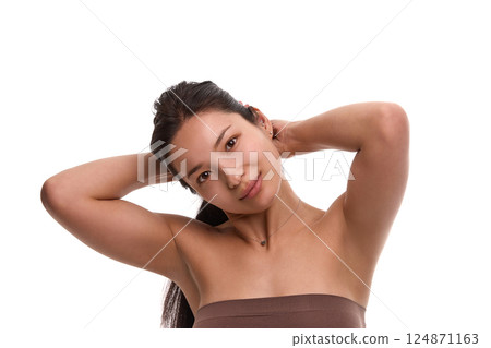 Relaxed woman with arms behind head and glowing natural skin isolated on white background. Relaxed woman with arms behind head and glowing natural skin isolated on white background. 124871163