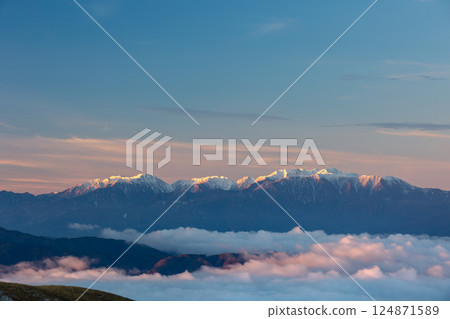 Winter dawn with the morning sun shining through the sea of clouds and the Central Alps 2 124871589