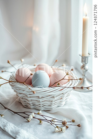 Pastel-colored eggs and flowers create a charming Easter arrangement with candlelight. 124871706