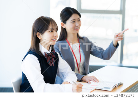 Female student and teacher studying 124872175