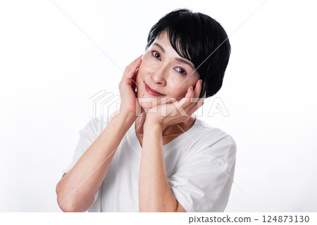 A middle-aged woman with short black hair smiling with her hand on her cheek A middle-aged woman with short black hair smiling with her hand on her cheek 124873130