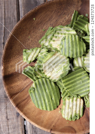 Jagged cut matcha chocolate potato chips served on an acacia plate Jagged cut matcha chocolate potato chips served on an acacia plate 124873728
