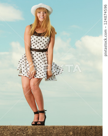 Beautiful retro style girl in polka dotted dress. Beautiful retro style girl in polka dotted dress. 124874596