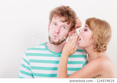 Woman telling an astonished man some secrets Woman telling an astonished man some secrets 124874619