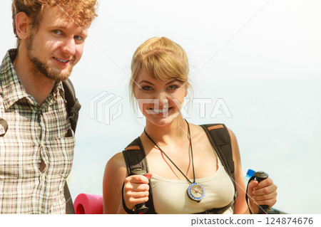 Two people tourists hiking by sea ocean. 124874676