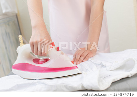 Hand of woman ironing Hand of woman ironing 124874719