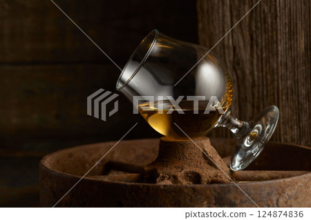 Cognac in snifter on old rusty wheel. Cognac in snifter on old rusty wheel. 124874836