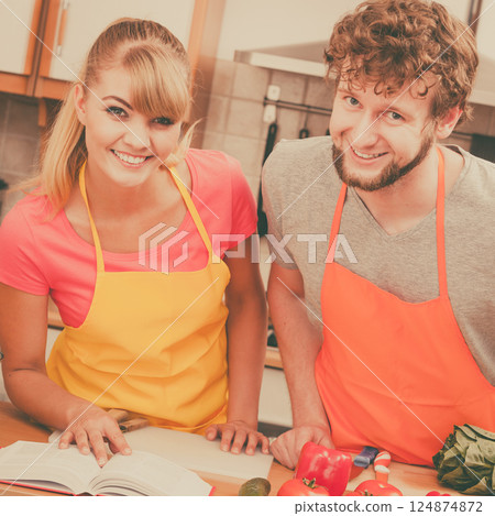Couple cooking in kitchen reading cookbook Couple cooking in kitchen reading cookbook 124874872