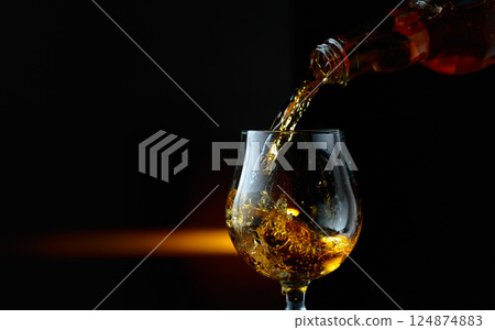 Brandy being poured into a glass. Brandy being poured into a glass. 124874883