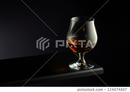 Brandy snifter on a dark background. 124874887