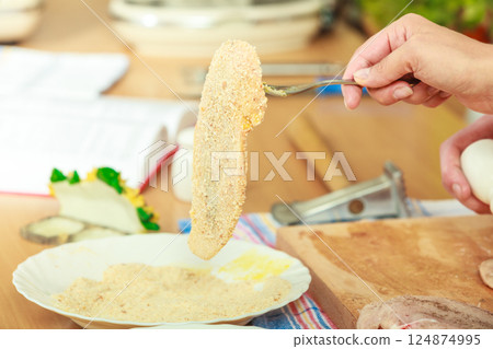 Preparing meal of breaded chicken cutlets 124874995