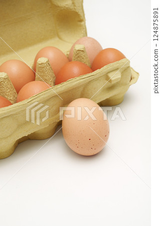 Farm egg near a green paper box. Close-up. 124875891