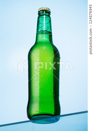 A cold beer bottle standing on a glass table A cold beer bottle standing on a glass table 124876945