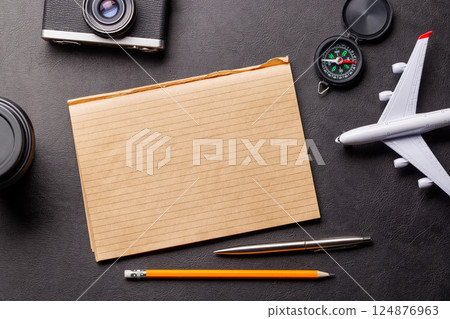 Creative flat lay of a travel-themed desk with notepad for plans Creative flat lay of a travel-themed desk with notepad for plans 124876963