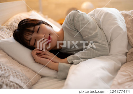 一個睡在床上的年輕女人 124877474