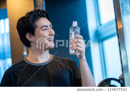 Man drinking water at the gym 124877503