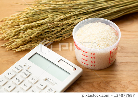 Rice in a measuring cup and a calculator 124877697