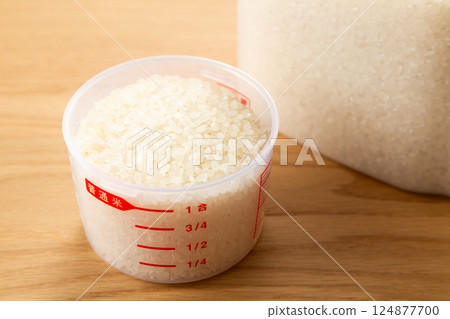 Rice in a measuring cup and a rice container Rice in a measuring cup and a rice container 124877700