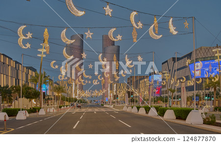 Lusail city, Qatar-March 21 2025: Lusail boulevard during Ramadan with illuminated decoration and the four Lusail towers Lusail city, Qatar-March 21 2025: Lusail boulevard during Ramadan with illuminated decoration and the four Lusail towers 124877870