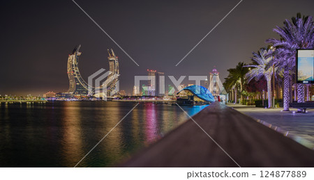 Lusail city, Qatar-March 20 2025: Katara Hospitality Tower, Crescent Tower, or Lusail Katara Hotel North Tower at night showing the unique architecture of the illuminated tower with Lusail marina Lusail city, Qatar-March 20 2025: Katara Hospitality Tower, Crescent Tower, or Lusail Katara Hotel North Tower at night showing the unique architecture of the illuminated tower with Lusail marina 124877889