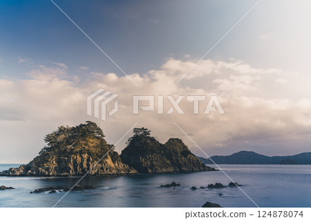 The rocks are illuminated by the setting sun, creating a sense of fantasy. 124878074